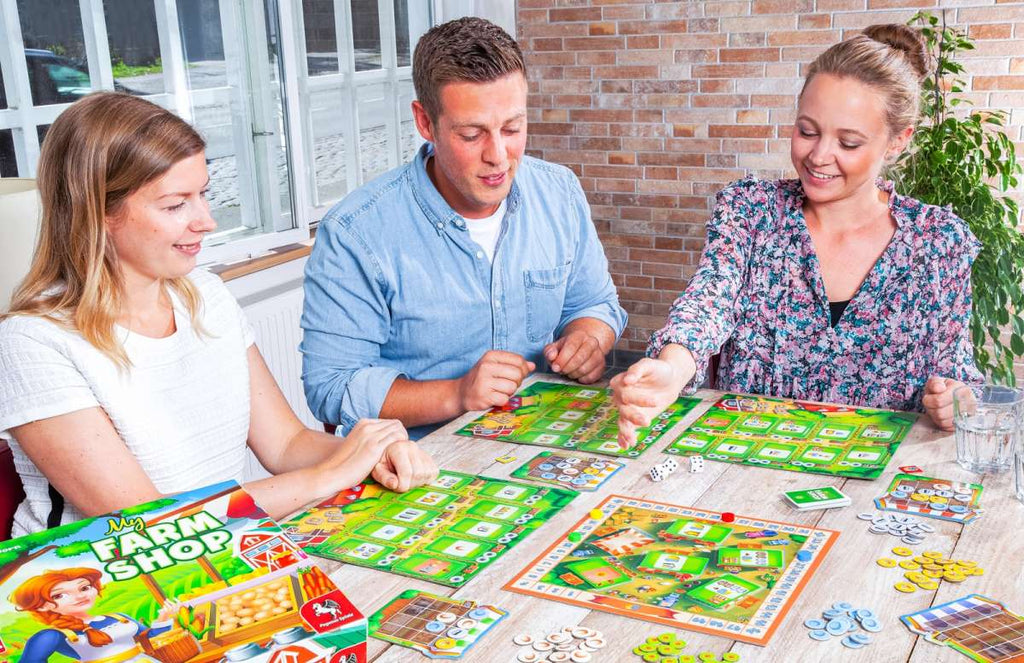 Pegasus Spiele My Farm Shop board game gameplay by three friends out on a porch