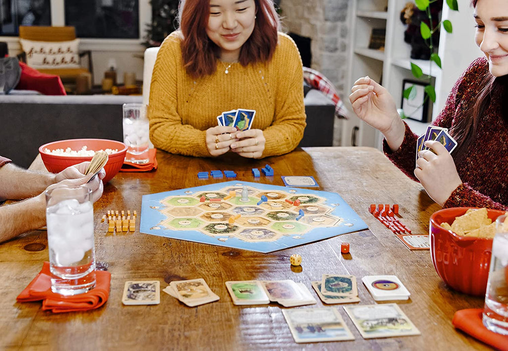 millennials playing catan board game on a Friday night