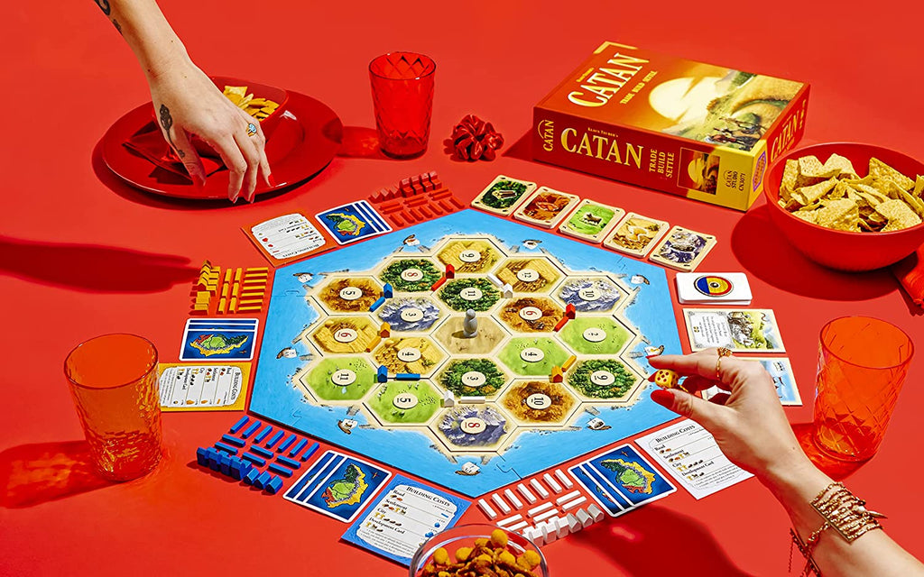 cool shot of catan board game with all contents displayed on a vivid red background