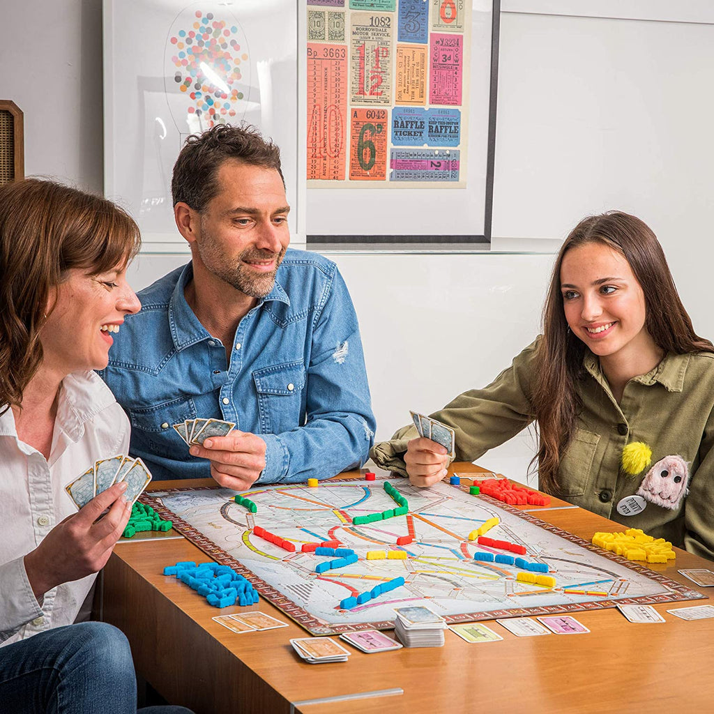 family playing ticket to ride usa board and smilingcover