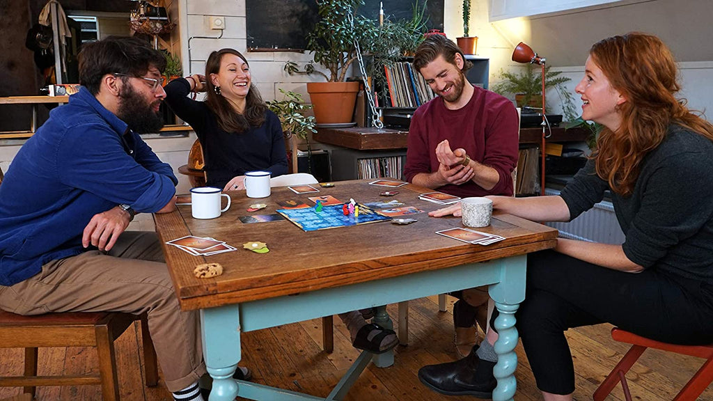 two couples playing dixit dixit board game and smiling