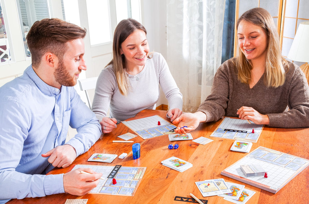 Pegasus Spiele Doodle Dungeon friends playing board game and a player rolls dice