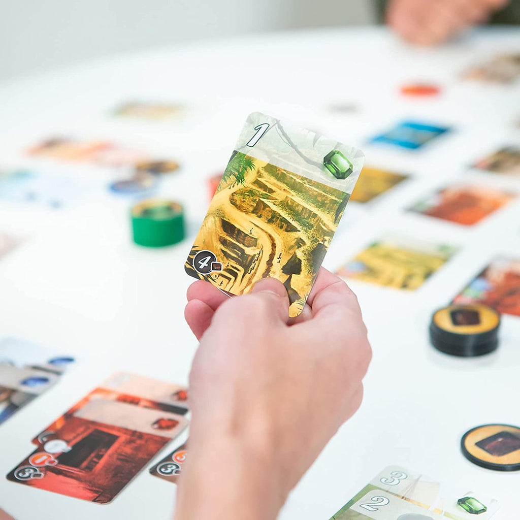 Space Cowboys Splendor board game a gamer holding a card 