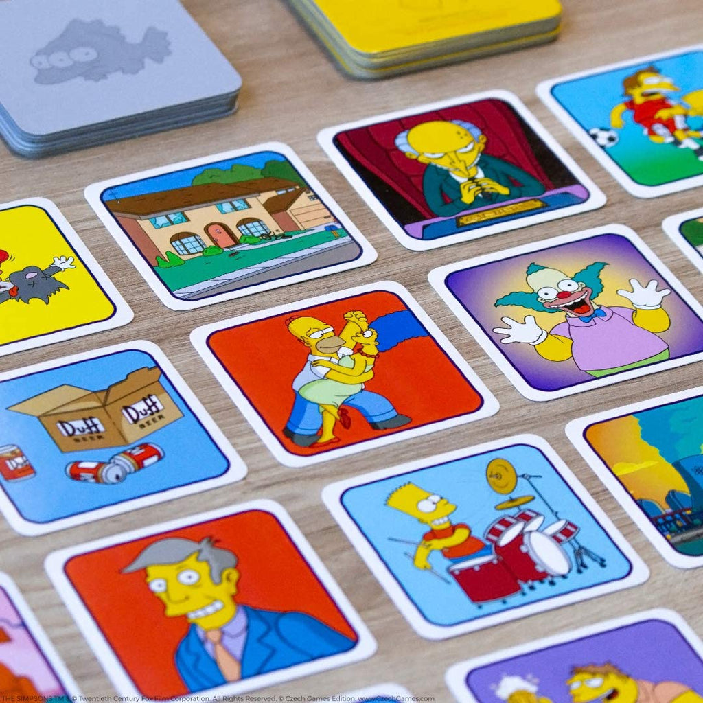 USAOPOLY Codenames The Simpsons Family Edition card gameplay in action with Bard drumming and Homer dancing